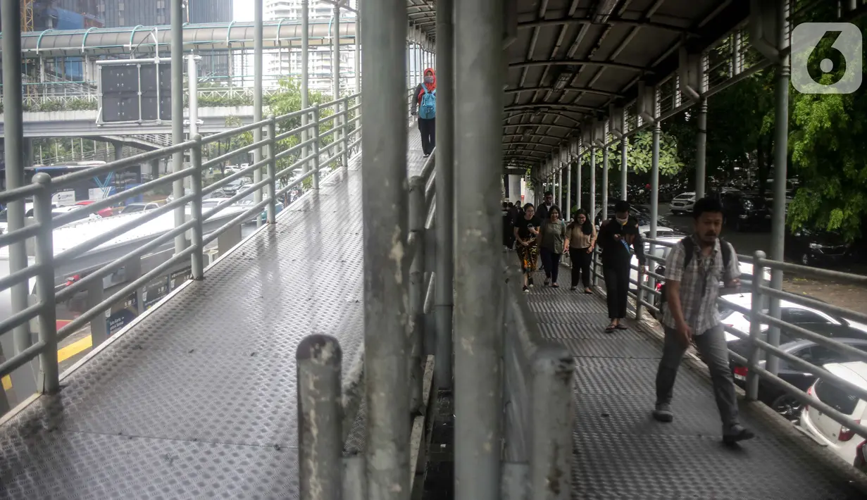 Sejumlah warga melintas di jembatan penyeberangan orang (JPO) dekat Unika Atma Jaya, Jakarta, Rabu (13/11/2019). JPO dekat Unika Atma Jaya dan Hotel Le Meridien di Jalan Jenderal Sudirman akan dicopot karena tidak berhubungan dengan halte Transjakarta. (Liputan6.com/Faizal Fanani)