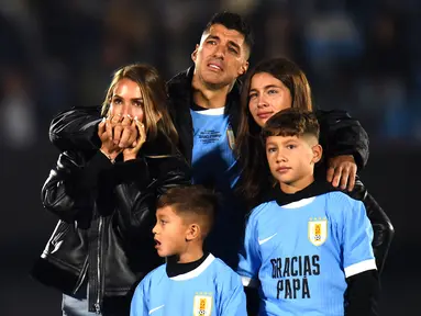 Pemain Uruguay, Luis Suarez (tengah) bersama istri (kiri) dan ketiga anaknya tak mampu membendung air mata saat acara perpisahannya dengan Timnas Uruguay sebelum laga kualifikasi Piala Dunia 2026 melawan Paraguay yang berlangsung di Stadion Centenario, Montevideo, Uruguay, Sabtu (07/09/2024) WIB. (AFP/Dante Fernandez)