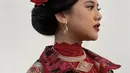 Untuk gaya rambut, Ziva tampil dengan sanggul dihiasi bunga mawar merah, dan poni sampingnya. [Instagram/ochiipramita]