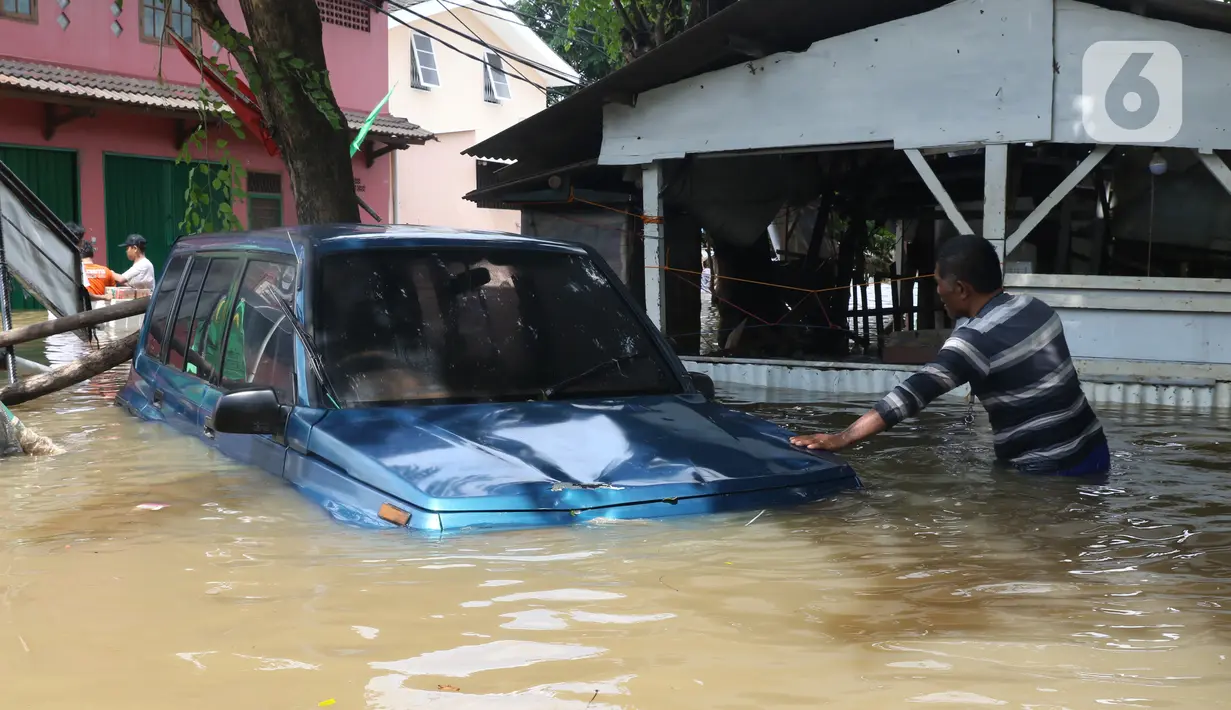 Warga melihat kondisi mobil yang terseret arus banjir di perumah Ciledug Indah, Tangerang, Banten, Kamis (2/1/2020). Sebelumnya, media sosial diramaikan dengan video sejumlah mobil yang terseret arus banjir hingga ratusan meter ke arah dalam perumahan Ciledug Indah. (Liputan6.com/Angga Yuniar)