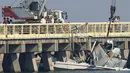 Tim penyelamat mengevakuasi badan pesawat yang menabrak jembatan, menggunakan alat berat di Shanghai, Tiongkok, Rabu (20/7). Pesawat amfibi ini mengalami kecelakaan di hari perdana mengudara. (REUTERS/Aly Song)