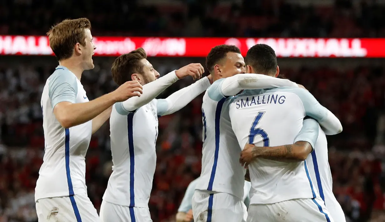 Pemain Inggris, Chris Smalling, disambut rekan-rekannya setelah mencetak gol ke gawang Portugal dalam laga persahabatan di Stadion Wembley, London, Kamis (2/6/2016). (AFP/Adrian Dennis)