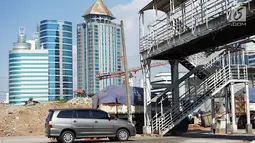 Kendaraan melintas di samping tangga akses JPO di Jalan Antasari, Jakarta, Jumat (24/5/2019). Proyek pelebaran jalan yang tidak dibarengi dengan pemanjangan JPO menyebabkan akses tangga JPO tersebut berada di tengah jalan. (Liputan6.com/Immanuel Antonius)