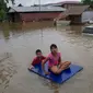 Warga menggunakan rakit menerobos banjir yang merendam di kecamatan Mawlamyine, negara bagian Mon, Myanmar (18/6). Hujan merendam rumah warga dan memaksa ratusan orang mengungsi. (AFP PHOTO / Ye Aung Thu)