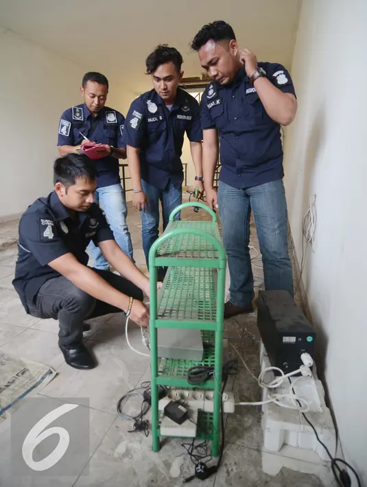 Petugas mengamankan sejumlah barang bukti di dua ruko yang ada di Graha Bintaro, Tangerang Selatan, Kamis (18/2). Penyegelan dua ruko hasil pengembangan penangkapan 7 orang tersangka dengan modus kejahatan penipuan online. (Liputan6.com/Faisal R Syam)