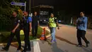 Aparat kepolisian berjalan menuju rumah mantan Perdana Menteri Malaysia, Najib Razak di Kuala Lumpur, Rabu (16/5). Polisi melakukan penggeledahan terkait dugaan pencucian uang di kediaman Najib usai Salat Tarawih. (AFP/Mohd RASFAN)