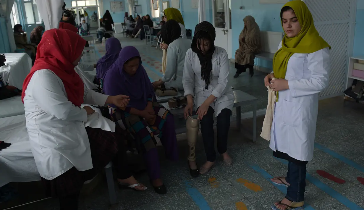 Seorang dokter Afghanistan (kedua kanan) memeriksa kondisi pasien yang diamputasi di pusat ortopedik Komite Internasional Palang Merah (ICRC), rumah sakit bagi korban perang dan yang diamputasi, di Kabul, Minggu (3/4).  (SHAH Marai/AFP)