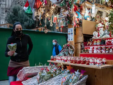Seorang wanita yang mengenakan masker melihat-lihat dekorasi Natal di Pekan Raya Santa Llucia, Barcelona, Spanyol, 1 Desember 2020. Pekan Raya Santa Llucia diadakan mulai 27 November - 23 Desember dengan kapasitas pengunjung dibatasi hanya 30 persen di tengah pandemi COVID-19. (Xinhua/Joan Gosa)