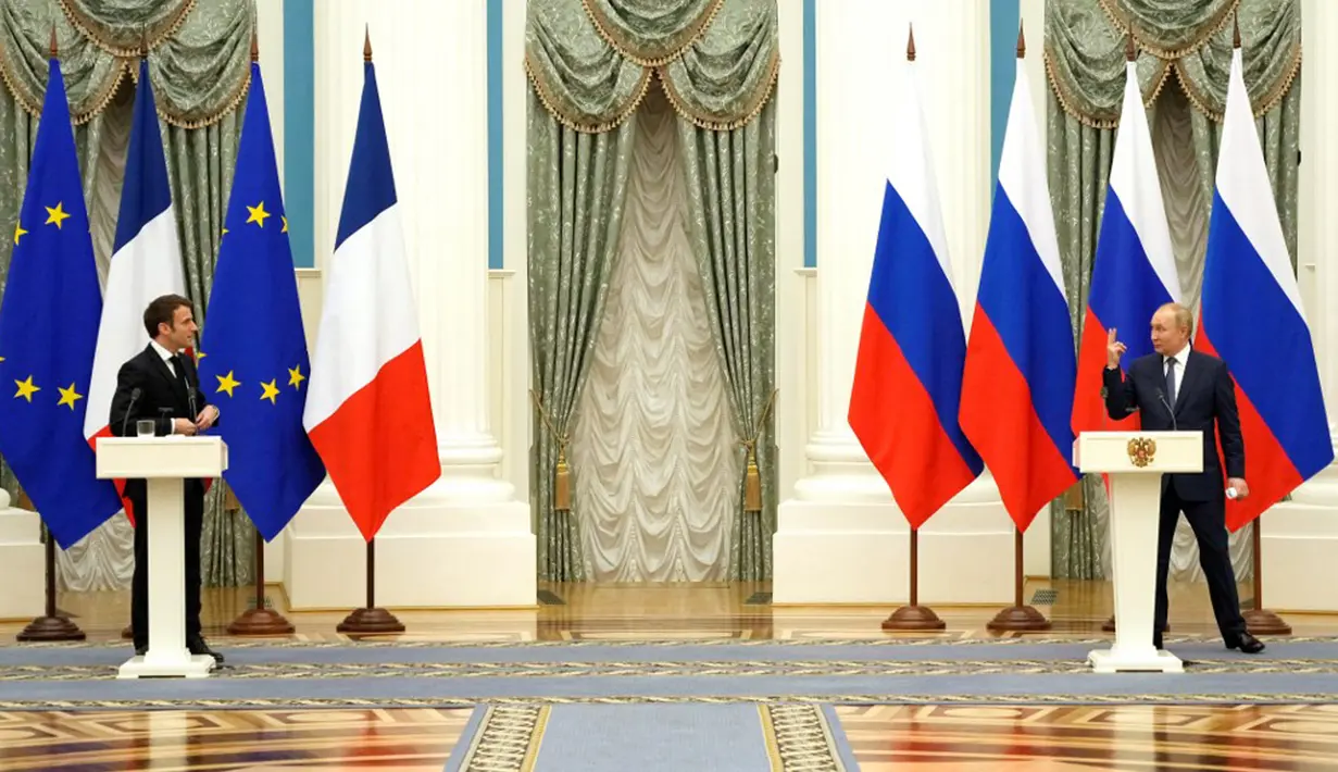 Presiden Rusia Vladimir Putin (kanan) memberi isyarat saat konferensi pers bersama Presiden Prancis Emmanuel Macron di Moskow, Rusia, 7 Februari 2022. Emmanuel Macron menemui Vladimir Putin untuk meredakan kebuntuan atas Ukraina. (Thibault Camus/POOL/AFP)