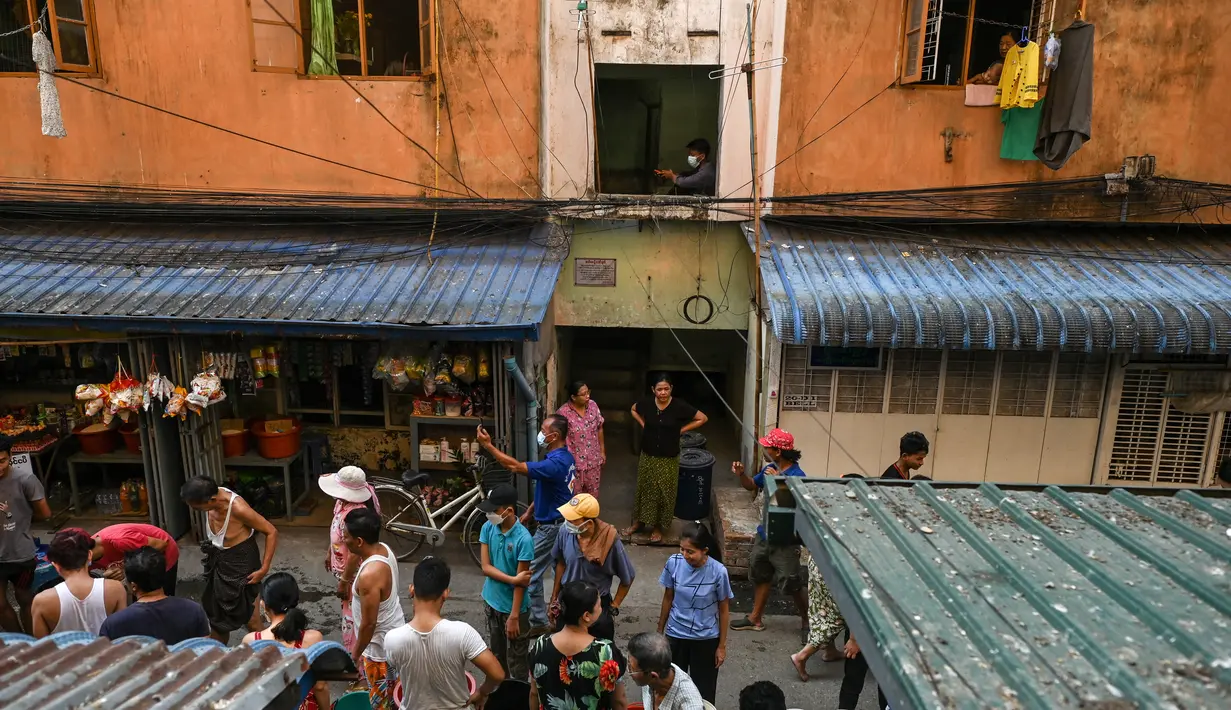 Orang-orang berkumpul di jalan untuk mengisi wadah dengan air di Yangon, Myanmar (14/3/2022). Ribuan orang menghadapi kekurangan air karena pemadaman listrik di kota tersebut. (AFP/STR)