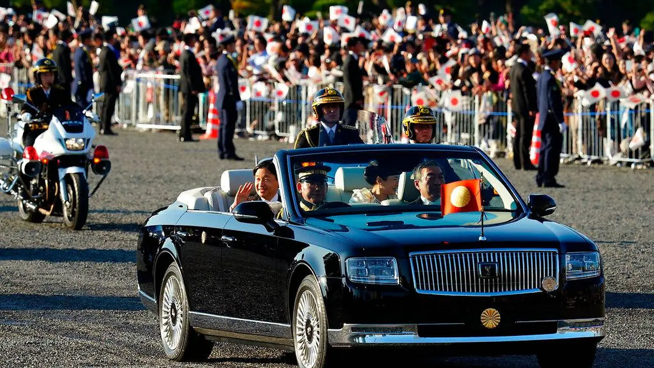 Kaisar Jepang, Naruhito dan Permaisuri Masako menyapa warganya selama parade di Tokyo, Jepang, Minggu (10/11/2019). (AP  Photo)