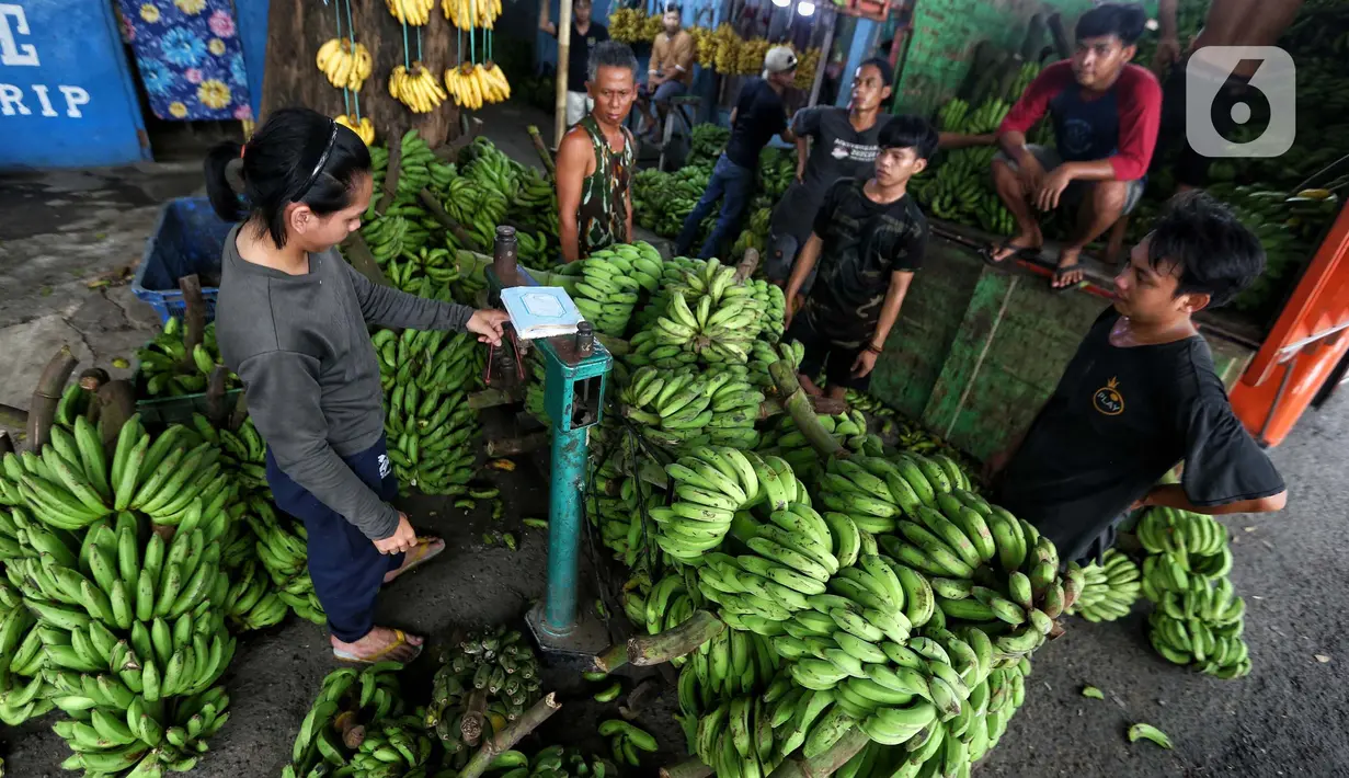 Pedagang tengah menurunkan pisang yang akan di jual di Pasar Lembang, Kota Tangerang, Kamis (28/3/2024). (Liputan6.com/Angga Yuniar)