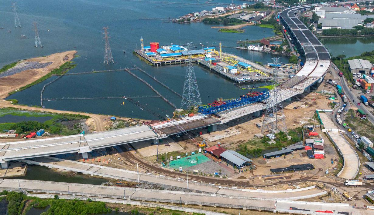 Sementara, konstruksi pembangunan ditargetkan rampung secara menyeluruh dan mulai beroperasi pada April 2027. Tampak dalam foto udara menunjukkan pembangunan Jalan Tol Laut Semarang-Demak, sebuah mega-proyek nasional yang dirancang untuk mengatasi banjir pasang surut air laut yang sering terjadi di sepanjang pantai utara, di Semarang, Jawa Tengah, pada Minggu 19 April 2026. (DEVI RAHMAN/AFP)
