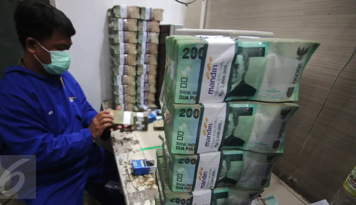 Petugas merapikan uang di Kantor Kas Bank Mandiri, Jakarta, Senin (4/1/2016). Nasib rupiah di tahun 2016 sulit menguat di tengah tingginya permintaan dollar. (Liputan6.com/Angga Yuniar)
