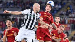 Pemain Udinese Bram Nuytinck (kiri) berebut bola dengan pemain AS Roma Nicolo Zaniolo pada pertandingan Serie A Liga Italia di Olympic Stadium, Roma, Italia, 23 September 2021. AS Roma menang 1-0. (Alberto PIZZOLI/AFP)