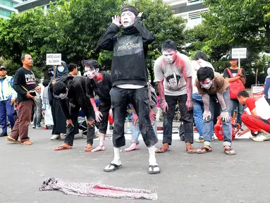 Massa aksi yang tergabung dalam Gerakan Solidaritas Umat Muslim menggelar teatrikal penembakan di Masjid Selandia Baru pada CFD di Bundaran HI, Jakarta, Minggu (17/3). Mereka mengutuk penembakan terhadap jemaah. (Liputan6.com/Herman Zakharia)