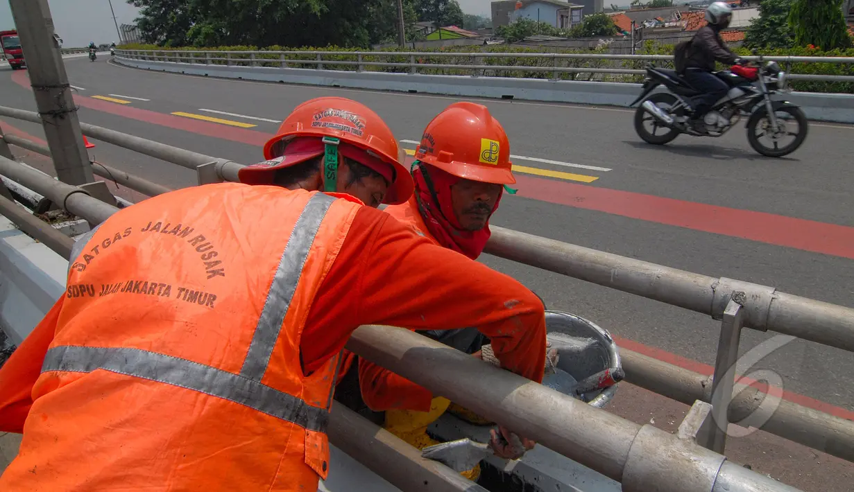 Sejumlah petugas Suku Dinas Pekerjaan Umum  melakukan peremajaan dengan melakukan pengecatan besi pembatas Fly Over di kawasan Cakung, Jakarta,  Rabu (1/4/2015). Panjang pembatas mencapai 120 meter (Liputan6.com/Yoppy Renato)