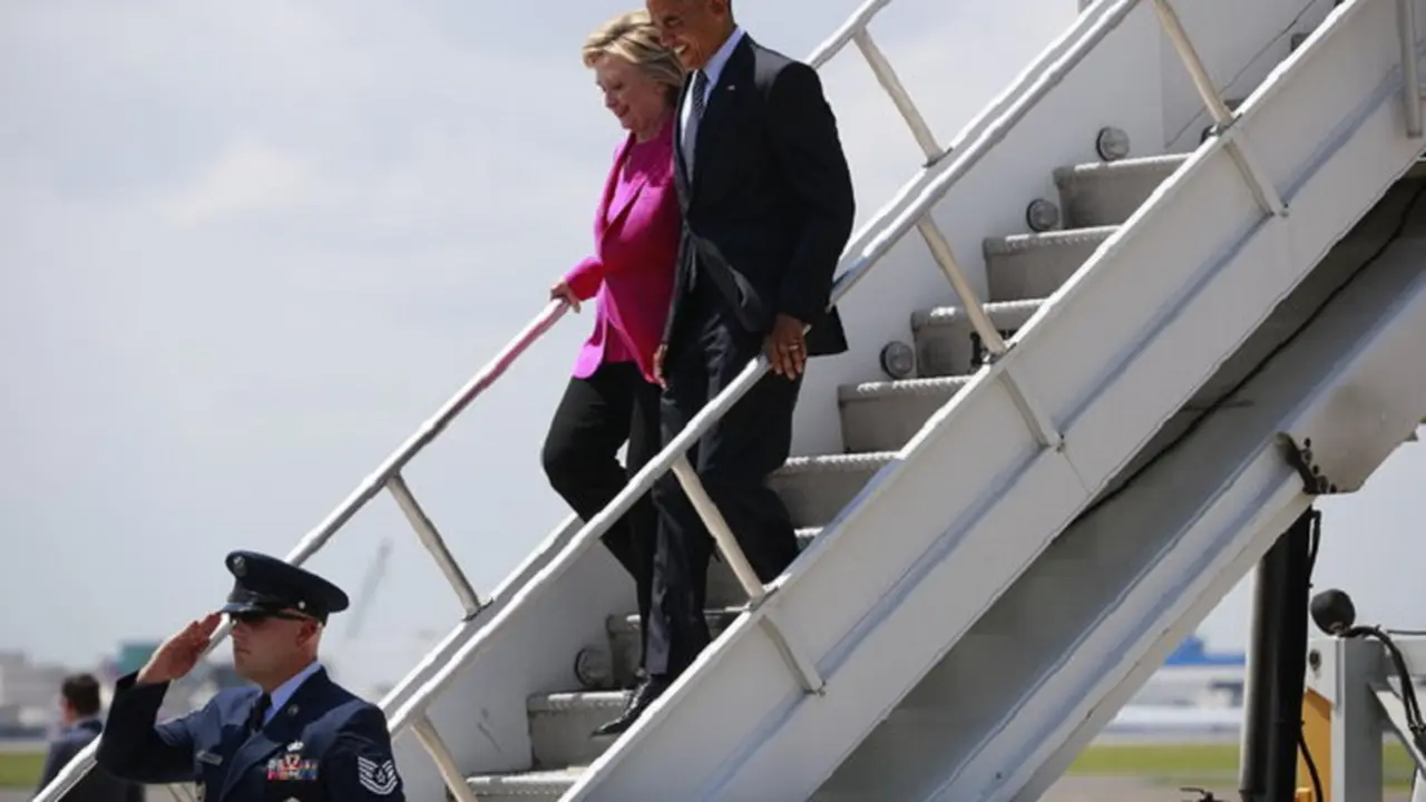 Presiden Obama dan Hillary Clinton menuruni tangga Air Force One 