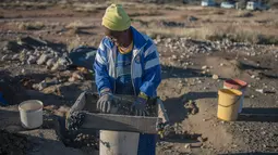 Seorang wanita lansia, Clara Maitse menyaring kotoran dan tanah saat mencari berlian di Kimberley, Northern Cape, Afrika Selatan (5/6). (AFP/Mujahid Safodien)