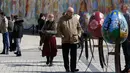 Pengunjung melihat telur Paskah yang dipajang di depan Katedral Mikhaylivsky di pusat Kiev sebelum perayaan Paskah, Ukraina, Rabu (12/4). Pameran telur Paskah ini biasa digelar menjelang perayaan Paskah. (AP Photo / Sergei Chuzavkov)