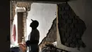 Seorang pria melihat kerusakan akibat gempa di rumahnya di sebelah Sungai Acari di kota Acari, provinsi Arequipa di Peru selatan (14/1). (AFP Photo/Str)