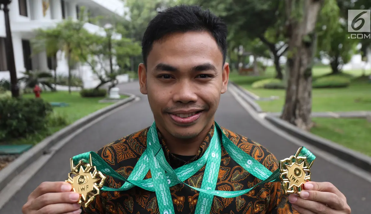 Lifter Indonesia, Eko Yuli Irawan menunjukkan medali di Istana Merdeka, Jakarta (8/11). Eko memecahkan rekor dunia untuk total angkatan 317 kg dan angkatan clean and jerk 174 kg di kejuaraan dunia angkat besi di Turkmenistan. (Liputan6.com/Angga Yuniar)