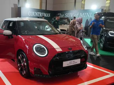 Orang-orang melihat kendaraan listrik MINI 1965 Victory Edition selama acara peluncurannya di Jakarta, Jumat 17 April 2026. MINI Indonesia secara resmi meluncurkan model edisi terbatas MINI 1965 Victory Edition. (AP Photo/Tatan Syuflana)