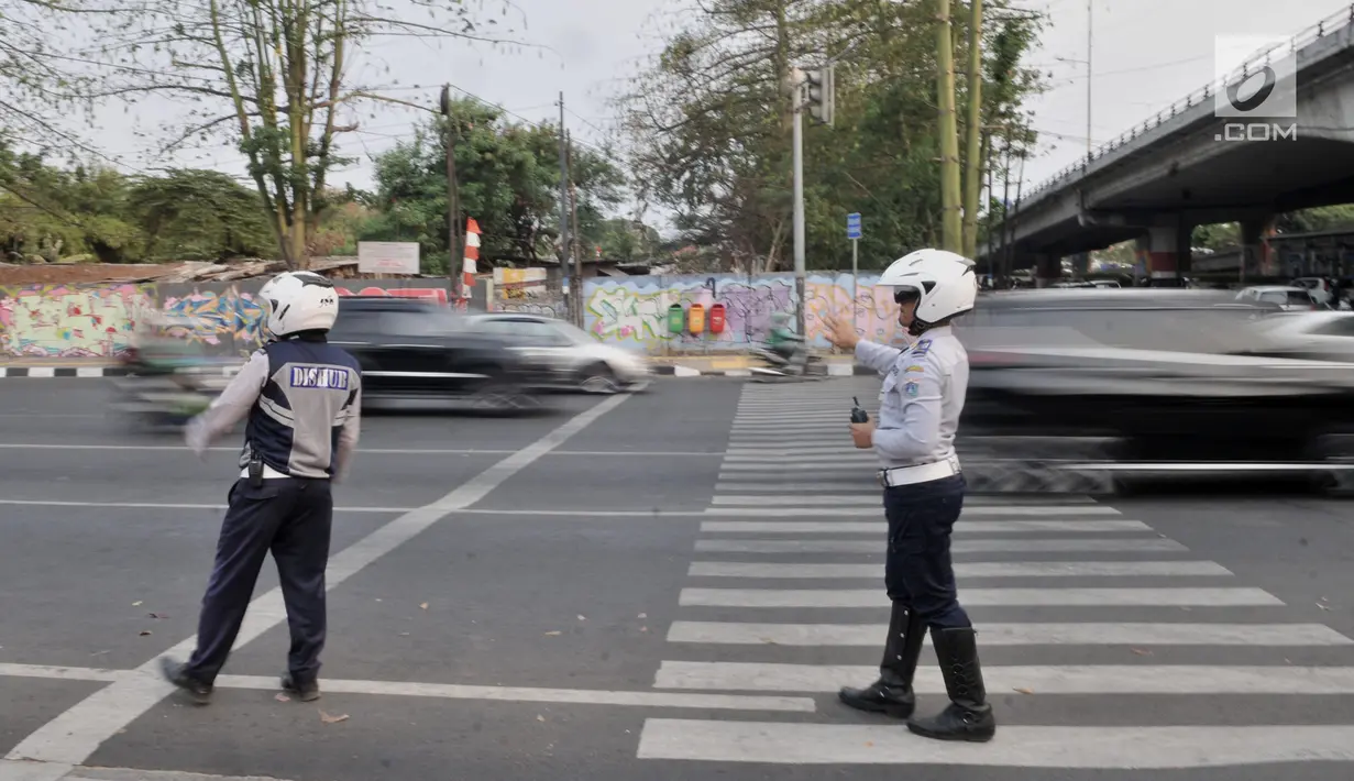 Petugas Dinas Perhubungan DKI Jakarta mengatur lalu lintas saat melakukan sosialisasi uji coba perluasan sistem ganjil genap di kawasan Pramuka, Jakarta, Senin (12/8/2019). Dinas Perhubungan DKI Jakarta melakukan uji coba perluasan sistem ganjil genap di 16 rute baru. (merdeka.com/Iqbal Nugroho)
