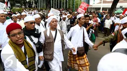 Penyanyi religi, Opick berjalan kaki bersama massa aksi damai 4 November melewati Balai Kota Jakarta menuju ke Istana Merdeka, Jumat (4/11). Aksi ini menuntut penuntasan proses hukum terhadap Basuki Tjahaja Purnama (Ahok). (Liputan6.com/Faizal Fanani)