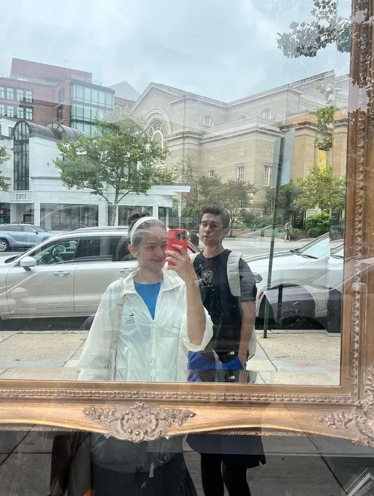 Mirror selfie yang menampilkan Enzy Storia dan Maulana Kasetra. Di sini Enzy tampil kasual dengan innerwear biru, ditumpuknya dengan jaket putih, yang serasi dengan bando yang dikenakannya. [Foto: Instagram/enzystoria]