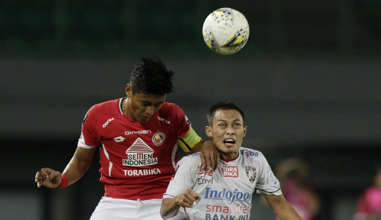 Bek Bali United, Dias Angga, duel udara dengan kapten Semen Padang, Irsyad Maulana, pada laga Piala Presiden 2019 di Stadion Patriot, Jawa Barat, Senin (11/3). Bali United menang 2-1 atas Semen Padang. (Bola.com/M Iqbal Ichsan)