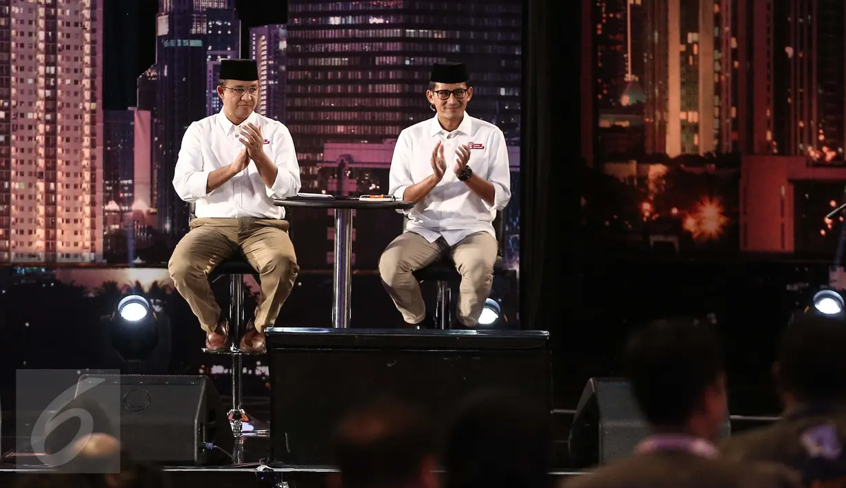 Cagub DKI Jakarta nomor 3 Anies Baswedan-Sandiaga Uno bertepuk tangan saat debat perdana Cagub DKI-Jakarta, Jumat (13/1). (Liputan6.com/Faizal Fanani)