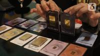 Karyawan menunjukkan kepingan emas yang dijual di Galeri 24, Jakarta, Selasa (15/12/2020). Harga emas hasil produksi PT Aneka Tambang Tbk (Antam) atau emas Antam kini turun Rp 1.000 per gram menjadi Rp 951 per gram pada perdagangan, Selasa (15/12). (Liputan6.com/Angga Yuniar)
