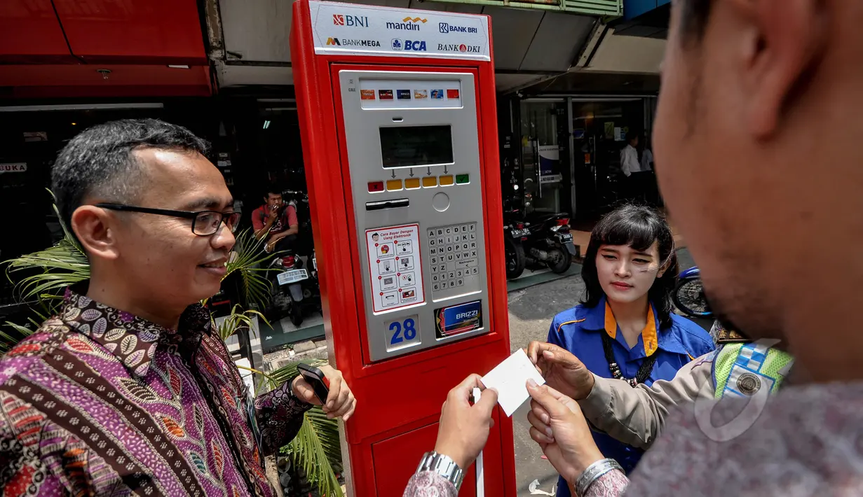 Seorang warga saat akan menggunakan mesin parkir elektronik ketika diresmikan di Jalan Boulevard Raya, Kelapa Gading, Jakarta, Rabu (25/3/2015). (Liputan6.com/Faizal Fanani)