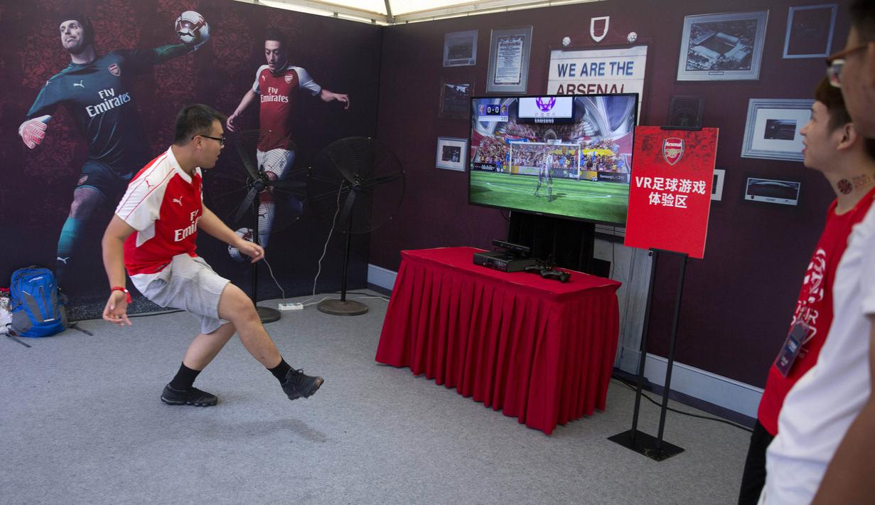 Fans Arsenal mencoba sebuah pertandingan sepak bola virtual reality di Beijing, Jumat, (21/7/2017). Arsenal dan Chelsea akan bertanding dalam laga persahabatan. (AP/Ng Han Guan)
