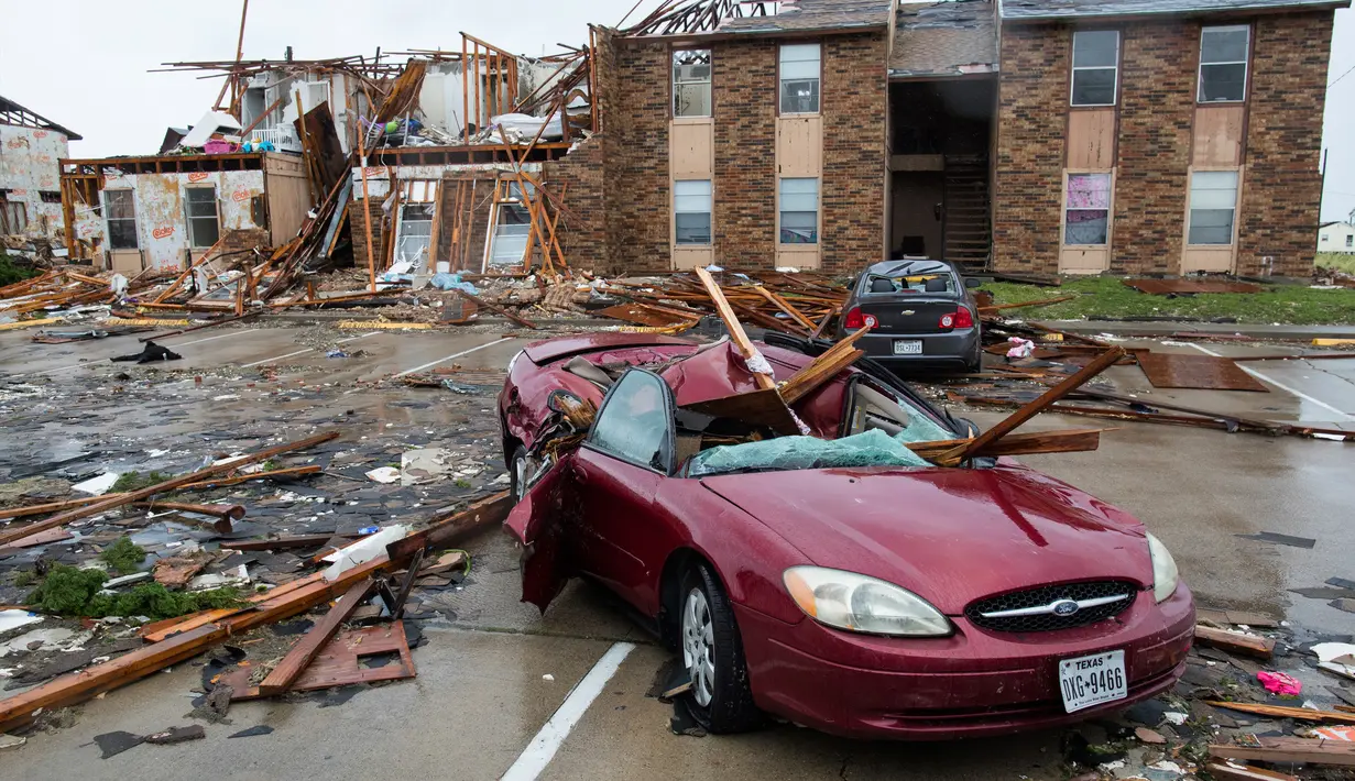 Sebuah mobil hancur tertimpa puing bangunan usai dilanda badai Harvey di Rockport, Texas (26/8). Akibat badai tersebut, Wali Kota Rockport Charles Wax mengungkapkan bahwa satu orang ditemukan meninggal. (Courtney Sacco/Corpus Christi Caller-Times via AP)