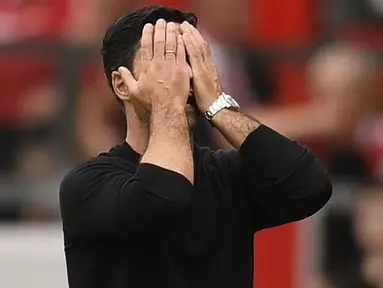 Ekspresi pelatih Arsenal, Mikel Arteta yang menutup wajahnya sebagai reaksi dari kekalahan timnya saat bertandang ke Markas Manchester United dalam pertandingan pekan keenam Liga Inggris 2022/2023. (AFP/Oli Scarff)