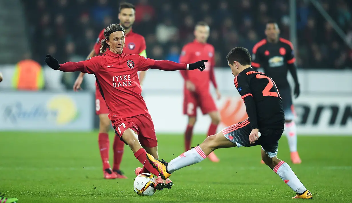 Pemain Midtjylland, Kristoffer Olsson (kiri), berebut bola dengan pemain MU, Ander Herrera, pada laga leg pertama 32 besar Liga Europa di Stadion MCH Arena, Hernin, Denmark, Jumat (19/2/2016) dini hari WIB. (AFP/Scanpix Denmark/Henning Bagger/)