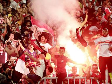 Para suporter Mesir menyalakan flare merayakan keberhasilan negaranya lolos ke Piala Dunia 2018 di Stadion Borg El Arab, Alexandria, Senin (8/10/2017). Mesir lolos ke Piala Dunia setelah absen sejak gelaran tahun 1990. (AP/Nariman El-Mofty)