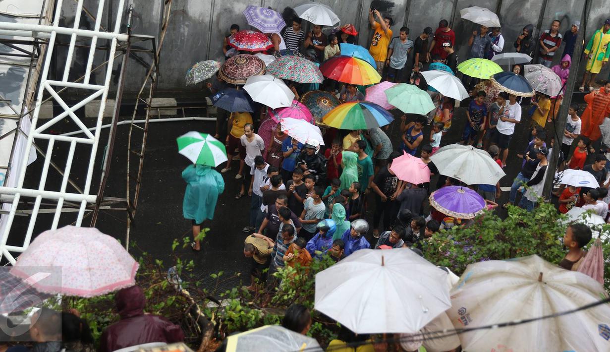 Warga menonton JPO yang roboh akibat hujan deras dan angin kencang di Jalan Raya Pasar Minggu, Jakarta Selatan, Sabtu (24/09). Keberadaan papan iklan dituding menjadi penyebab ambruknya JPO. (Liputan6.com/Immanuel Antonius)
