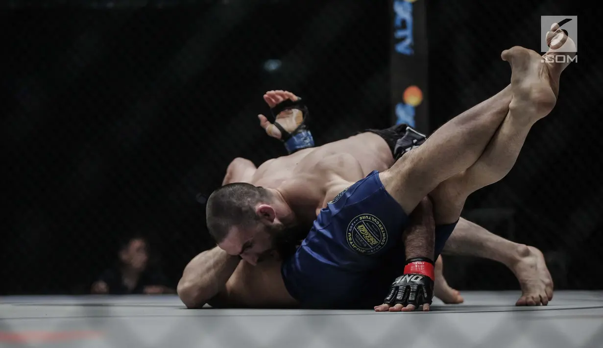 Petarung Rusia, Yusup Saadulaev (atas) berusaha mengunci petarung Jepang, Masakazu Imanari saat berlaga pada One Championship di Jakarta Convention Center (JCC), Sabtu (20/1). Pertarungan dimenangkan oleh Yusup Saadulaev. (Liputan6.com/Faizal Fanani)