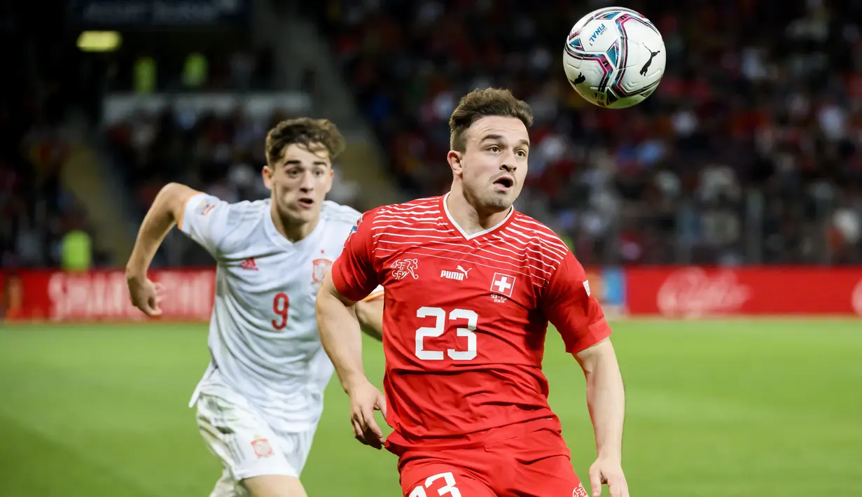 Pemain Spanyol Gavi (kiri) berebut bola dengan pemain Swiss Xherdan Shaqiri pada pertandingan sepak bola UEFA Nations League di Stadion Stade de Geneve, Jenewa, Swiss, 9 Juni 2022. Spanyol menang 1-0. (Jean-Christophe Bott/Keystone via AP)