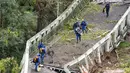 Tim penyelamat berjalan di atas jembatan gantung yang ambruk di atas sungai Tarm, Prancis, Selasa (18/11/2019). Jembatan gantung yang menghubungkan kota Mirepoix-sur-Tarn itu tiba-tiba ambruk hingga menyebabkan seorang gadis berusia 15 tahun dan satu sopir truk tewas. (ERIC CABANIS/AFP)