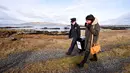 Margaret Byrne (kiri) berjalan mengawal pejabat ketua, Majella Harkin saat mendistribusikan kotak suara di Inishfree, Irlandia, Kamis (25/2). Pulau terpencil ini hanya terdapat empat orang yang memiliki hak pilih. (REUTERS/Clodagh Kilcoyne)