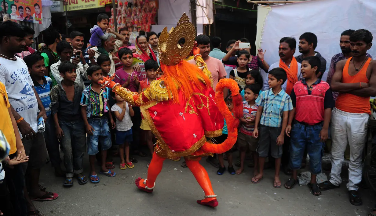 Seorang pria India berpakaian seperti dewa monyet Hanoman memberkati warga setempat saat prosesi festival Jayanti di Allahabad, India (18/10). Festival ini untuk memperingati kelahiran dewa Hindu Hanoman. (AFP Photo/Sanjay Kanojia)
