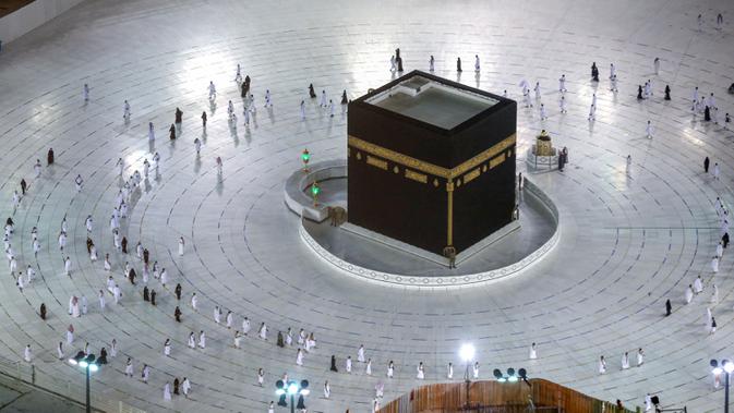 Warga Saudi dan warga asing mengelilingi Ka'bah (tawaf) saat melaksanakan umrah di kompleks Masjidil Haram, kota suci Makkah, Minggu (4/10/2020). Arab Saudi mengizinkan kembali ibadah umrah usai peringanan pembatasan sosial dan karantina wilayah di tengah pandemi Covid-19 di Tanah Suci. (AFP)