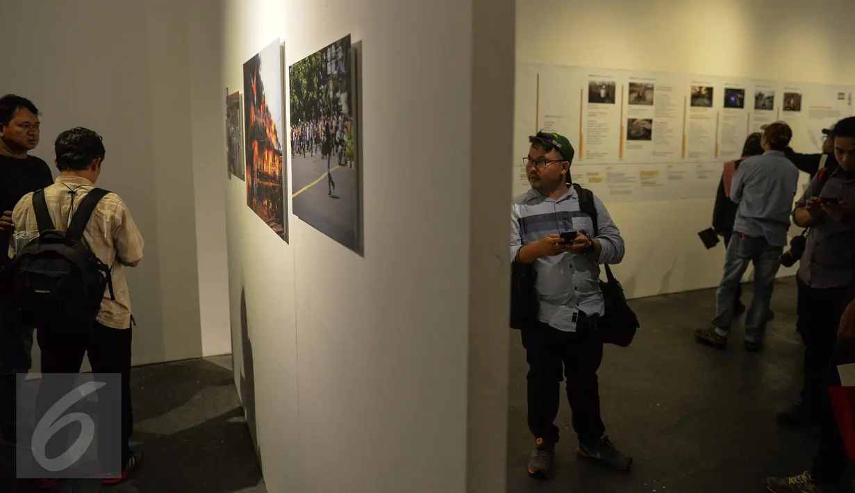 Seorang pengunjung melihat pameran Anugerah Pewarta Foto Indonesia (APFI) 2017 di Jakarta, Jumat (21/4). Sebanyak 15 karya foto jurnalistik terbaik telah dipilih dari 5.488 karya foto yang dikirimkan oleh 410 pewarta foto. (Liputan6.com/Faizal Fanani)