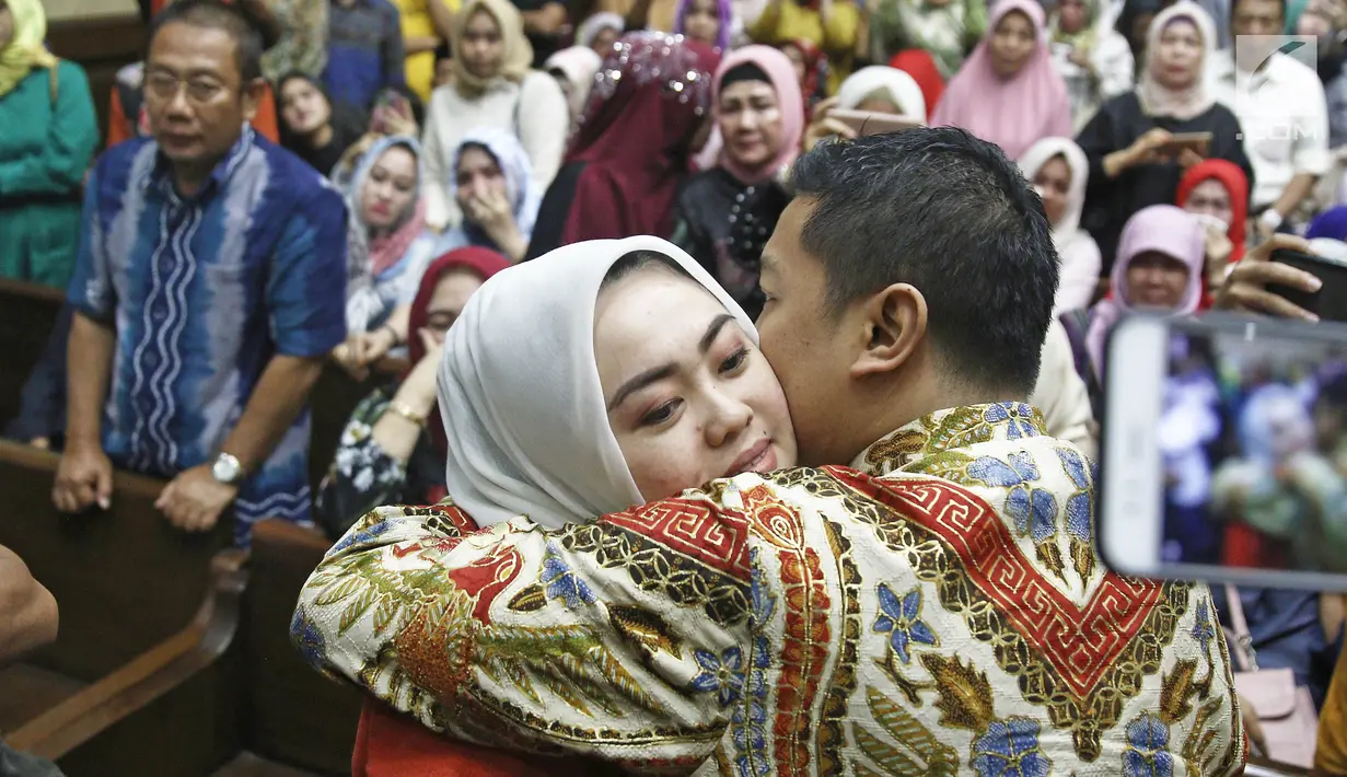 Wali Kota nonaktif Kendari Adriatma Dwi Putra memeluk istrinya usai menjalani sidang vonis di  Pengadilan Tipikor, Jakarta, Rabu (31/10). Adriatma divonis 5 tahun 6 bulan penjara dan denda Rp 250 juta terkait dugan suap. (Liputan6.com/Herman Zakharia)