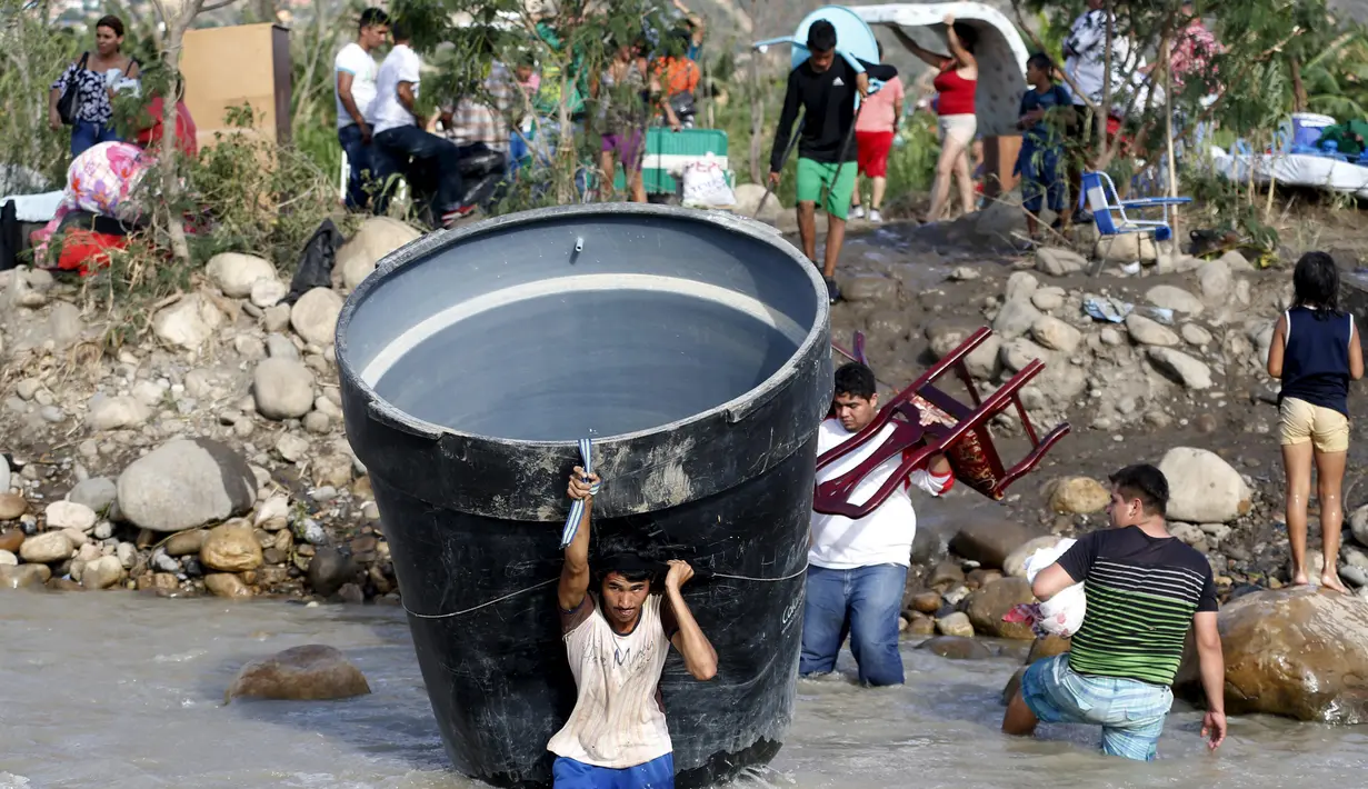 Sejumlah Warga Kolombia membawa barang-barang mereka saat melintasi sungai Tachira, Venezuela, (25/8/2015). Sebanyak 1.012 warga Kolombia dideportasi dari Venezuela. (REUTERS/Jose Miguel Gomez)