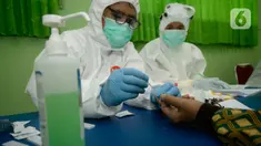 Petugas melakukan pemeriksaan cepat COVID-19 (Rapid Test) kepada tenaga pendidik SMP di SMPN 3 Ciputat, Tangerang Selatan, Kamis (27/08/2020). Rapid tes yang diikuti 400 guru mencakupi wilayah Ciputat dan Ciputat Timur itu untuk mencegah penyebaran Covid-19 di lingkungan pendidikan. (merdeka.com/Dwi